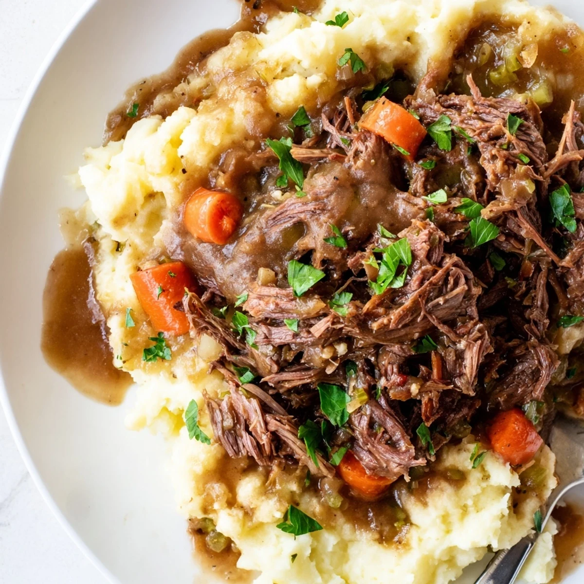 Slow Cooker Pot Roast with Mashed Potatoes served with rich, savory gravy and fresh parsley.  