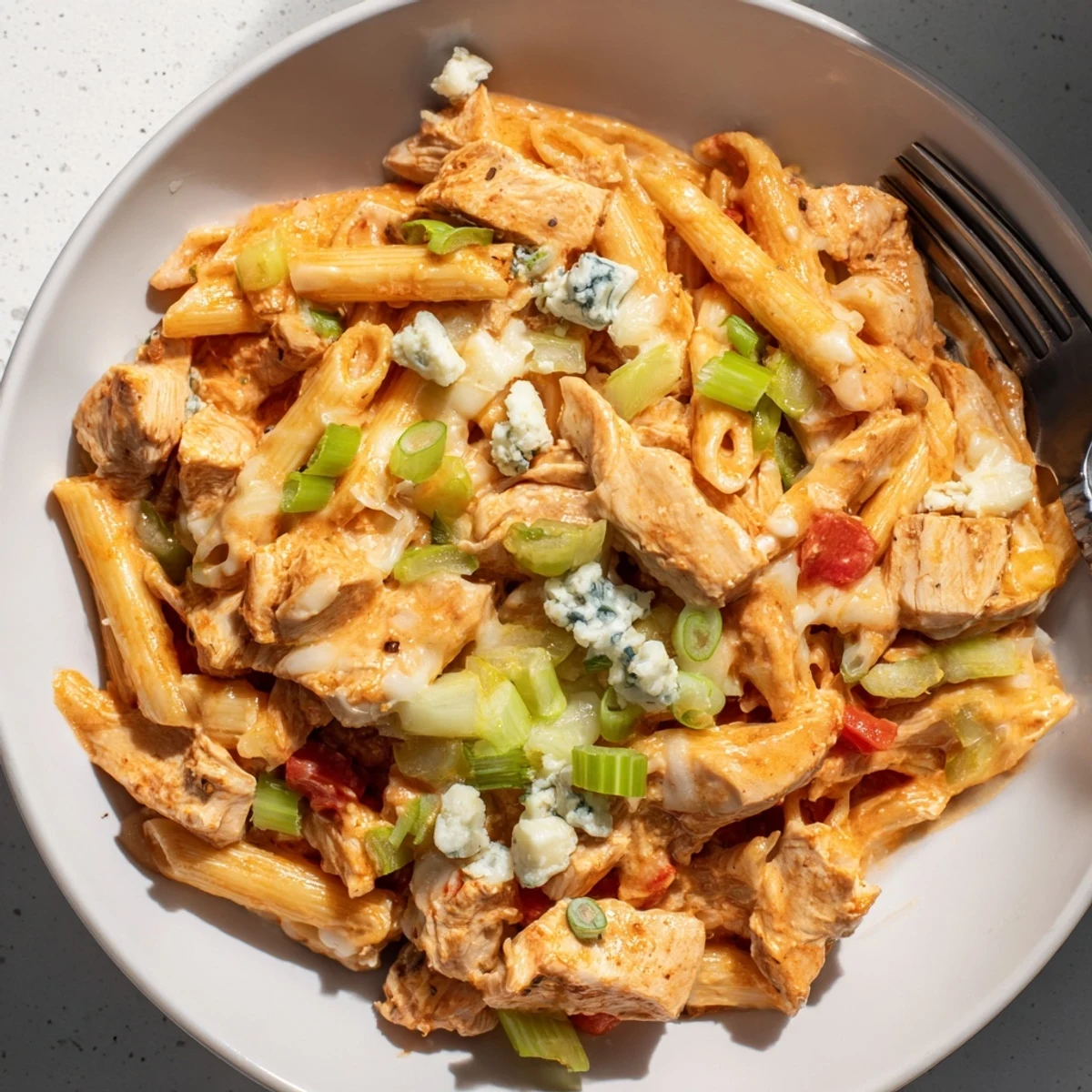 Creamy, cheesy Buffalo Chicken Pasta Skillet, a one-pan meal with visible shredded chicken and vibrant red peppers.