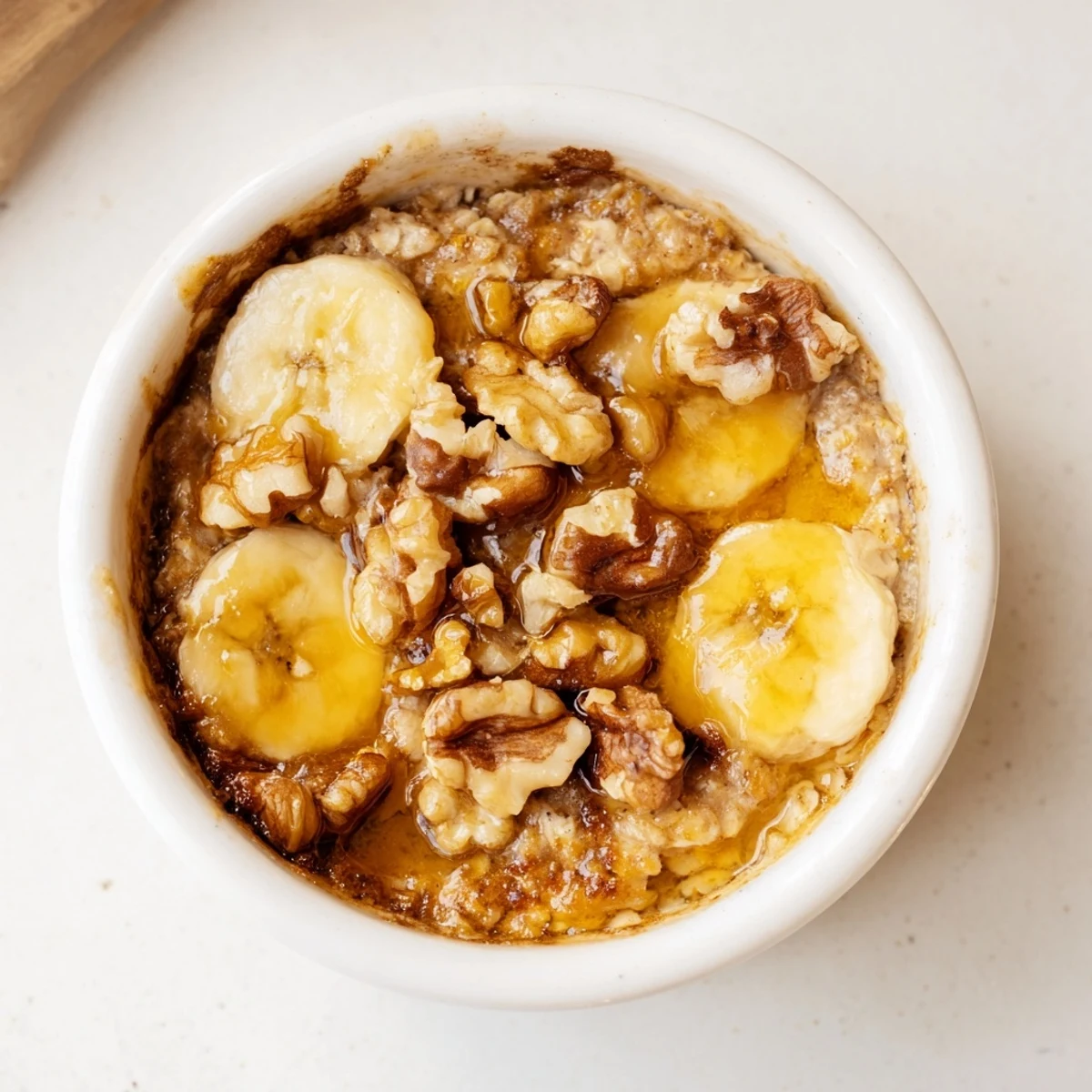 Creamy baked oats ramekins with banana, golden brown, awaiting a drizzle of sweet honey.