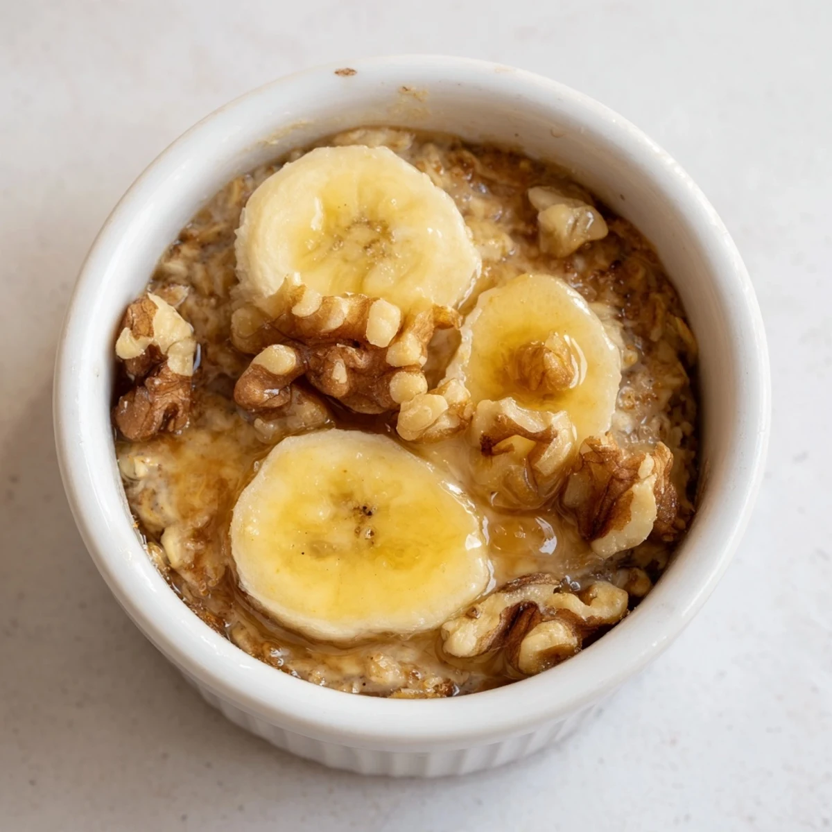 Enjoy the delicious aroma of baked oats ramekins recipe, with a topping of fresh banana slices.