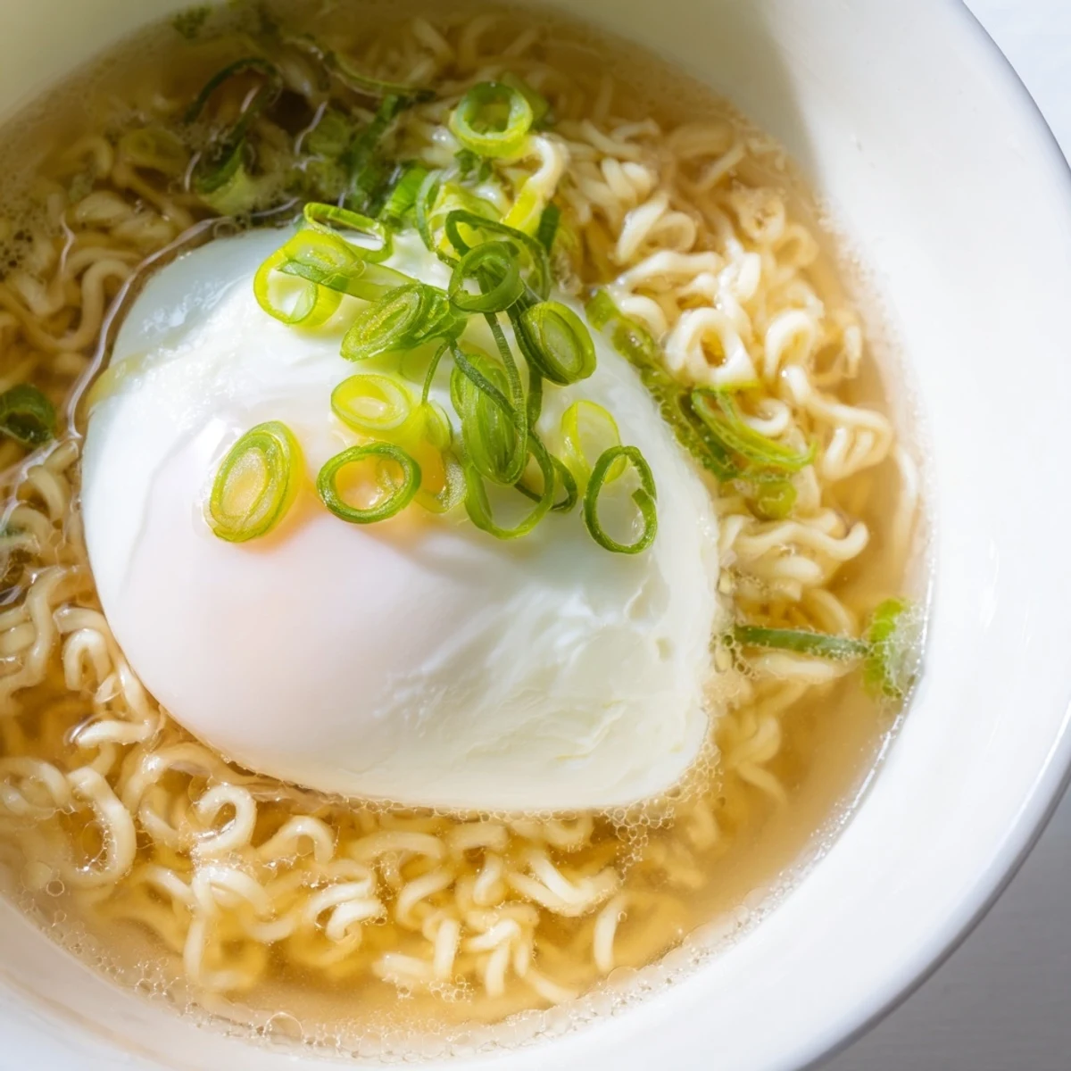 Steaming bowl of upgraded instant ramen with a perfectly cooked soft egg, ready to eat.