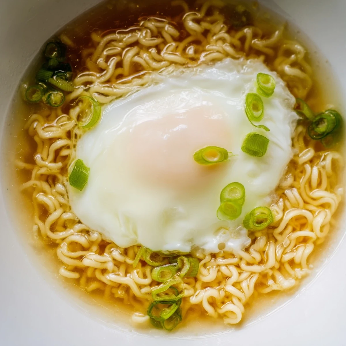 Close-up of the flavorful, buttery broth surrounding the upgraded instant ramen noodles.