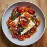 Tender pasta swims in a rich sauce from One-Pan Baked Feta Christmas Pasta, garnished with fresh basil.