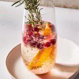 Sparkling Snow Globe Mocktail with vibrant orange slices and cranberries makes a beautiful, bubbly drink.