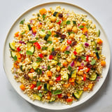 A bright bowl of Moroccan Couscous Salad, showing off roasted vegetables and a zesty lemon dressing.