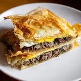 Mouthwatering photo: close-up of flaky Tunisian brik pastry, fried to a perfect golden hue.