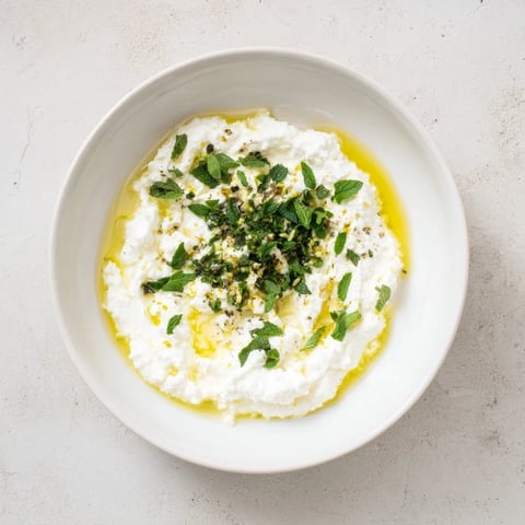 Creamy whipped feta dip with vibrant lemon-mint drizzle, ideal for dipping pita.