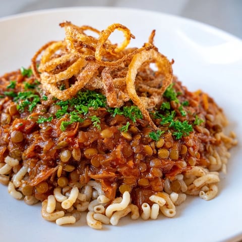 Golden, crispy onions top a vibrant bowl of Egyptian Koshari, a flavorful vegan dish.