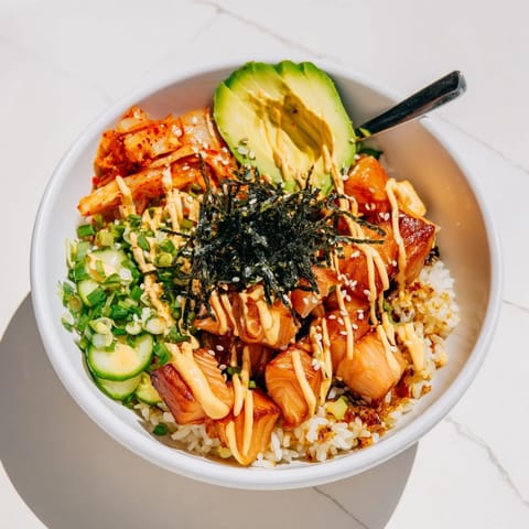 Deliciously layered crispy salmon rice bowl, topped with garlic, cucumber, and creamy avocado.  
