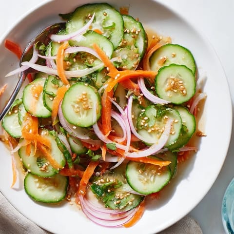 Refreshing cucumber salad remix featuring colorful veggies, Asian flavors, and a tangy dressing.  