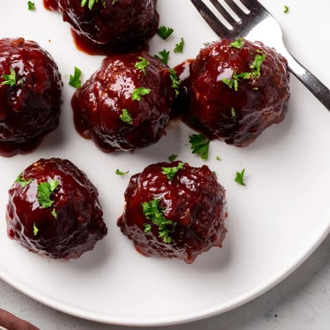 A close-up of tender, flavorful cherry BBQ meatballs, perfect for potlucks or game day spreads.