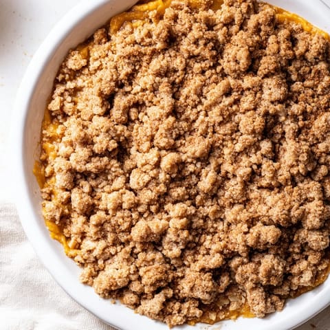 A close-up of warm, bubbly Pumpkin Crisp, inviting you to imagine its spiced aroma and flavor.