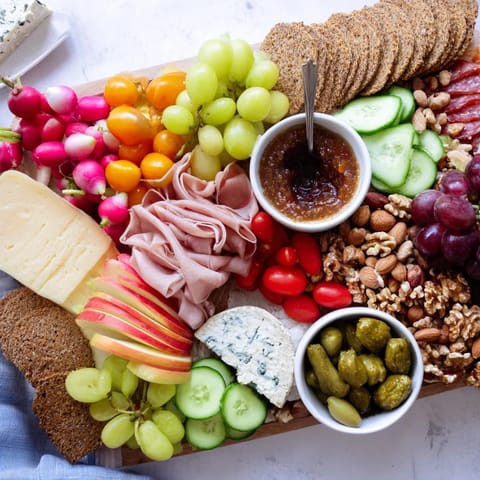 A visually stunning Cheval Heureux Snack Board with colorful produce and an assortment of cheeses.