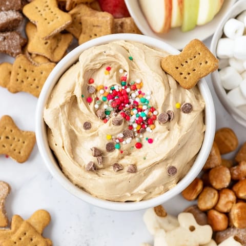 A festive Gingerbread House Dip Board, showcasing the creamy dip alongside gingerbread cookies and pretzels.