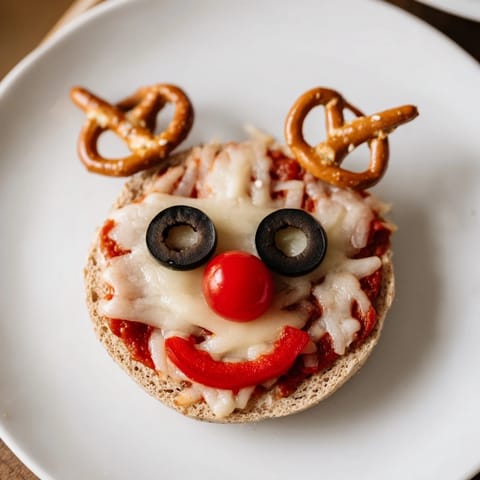 Warm, melted cheese covers a delicious Reindeer Face Pizza Bagels with bright red noses and pepppers.