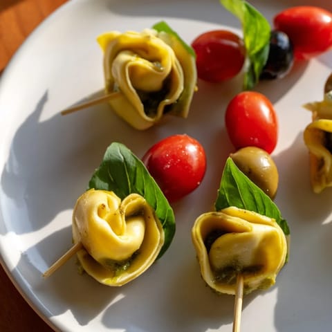 These vibrant Appetizer Skewers display perfectly arranged tortellini, olives, and pesto, a delicious bite.
