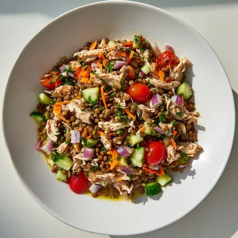 The Chicken and Lentil Recession Salad showcases diced tomatoes, cucumbers, and chicken; a vibrant and healthy meal.