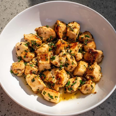 Juicy garlic butter chicken bites glistening, perfect bite-sized pieces with a creamy sauce.
