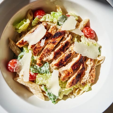 Freshly made Spicy Chicken Caesar Pasta topped with golden chicken, crunchy croutons, and shaved Parmesan cheese.