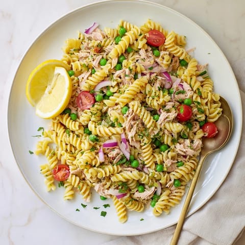 A refreshing Lemony Tuna Pasta Salad served in a white bowl, perfect for a light summer lunch or picnic.  