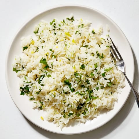 Heaping spoonful of cilantro lime rice served warm beside grilled chicken and vibrant taco toppings.