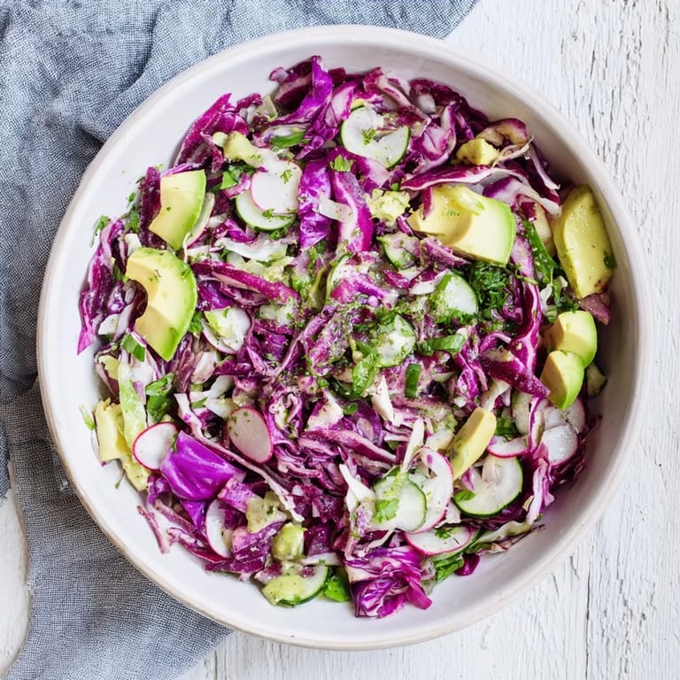 Tossed and ready to serve, a big bowl of Green Goddess Detox Cabbage Salad, a healthy vegan meal.