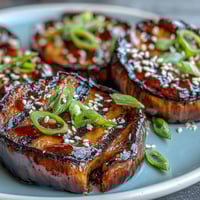 Golden miso glazed eggplant with a glossy caramelized finish, perfect as a vegetarian main or side dish.